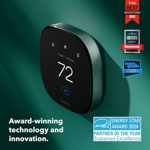 Smart thermostat on wall with multiple awards displayed.